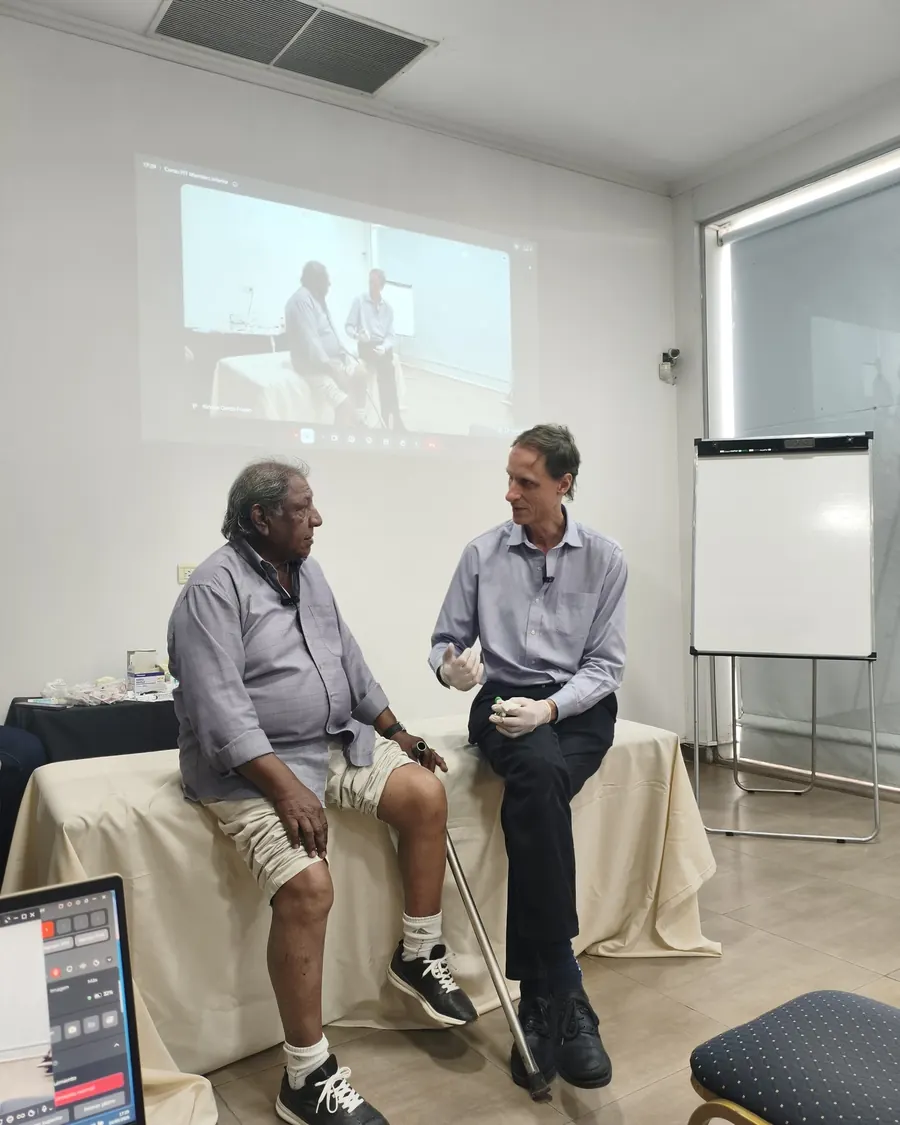 El Dr. Frusso conversa con un paciente frente al grupo antes del tratamiento.